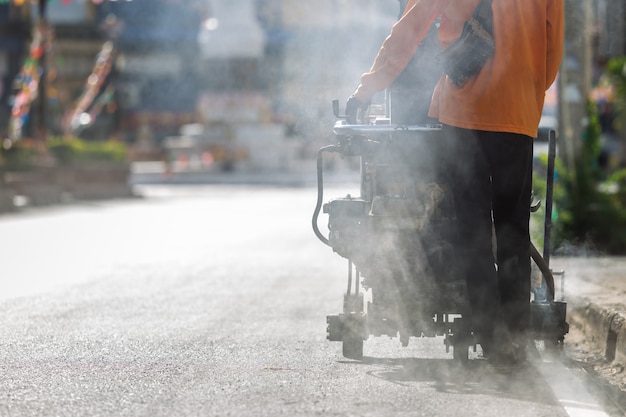 Mens die machine met behulp van om verkeerslijnstreep op de weg te maken