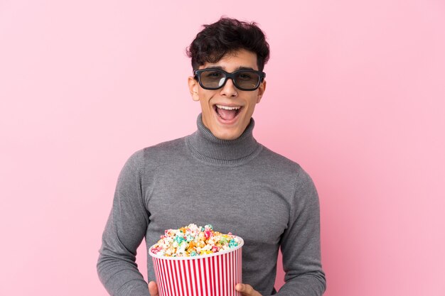 Mens die met baard popcorns over geïsoleerde muur houden