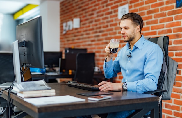 Mens die met computer op bedrijfkantoor werkt.