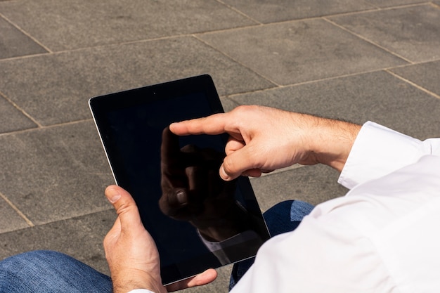 Foto mens die met zijn vinger op het scherm van digitale tablet richt