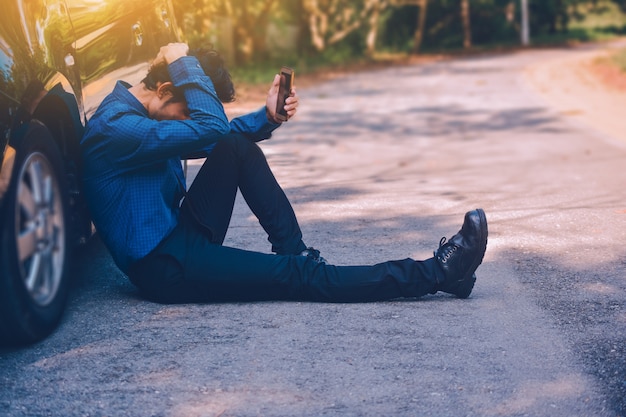 Mens die mobiele slimme telefoon en technologie online Internet houden voor het winkelen met zaken in auto