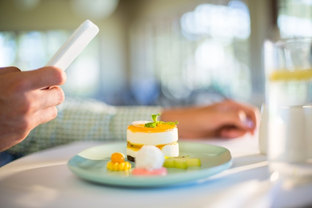 Mens die mobiele telefoon met behulp van terwijl het hebben van een lunch