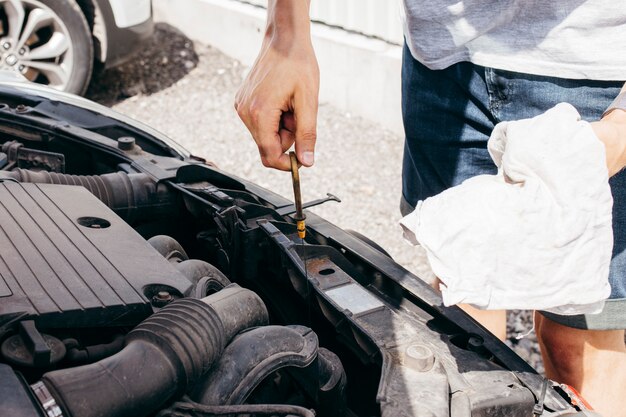 Mens die motorolie in een auto controleert