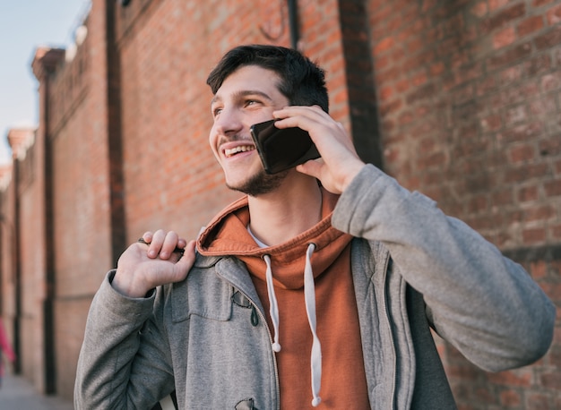 Mens die op de telefoon in openlucht spreekt.