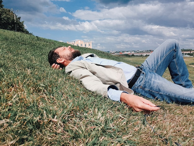 Foto mens die op het gras rust