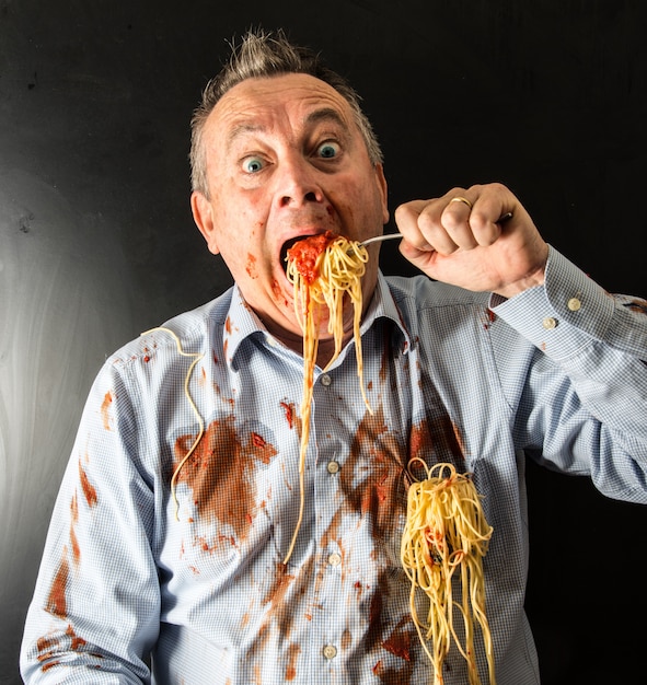Mens die spaghetti met tomatensaus eet
