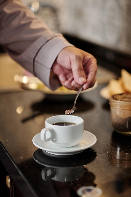 Mens die Suiker in Koffie zet