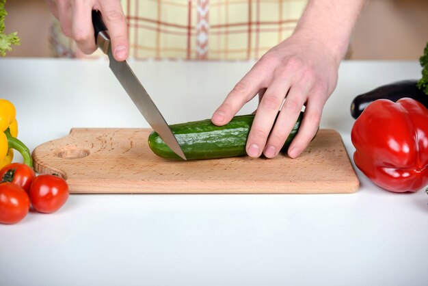 Mens die thuis voorbereidend salade in keuken koken.