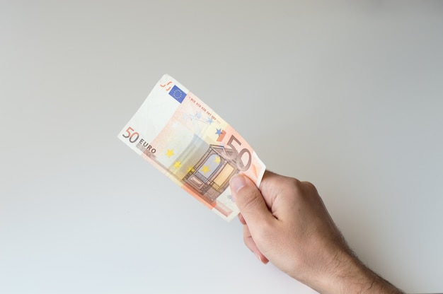 Mens die vijftig Euro bankbiljet in zijn hand houdt