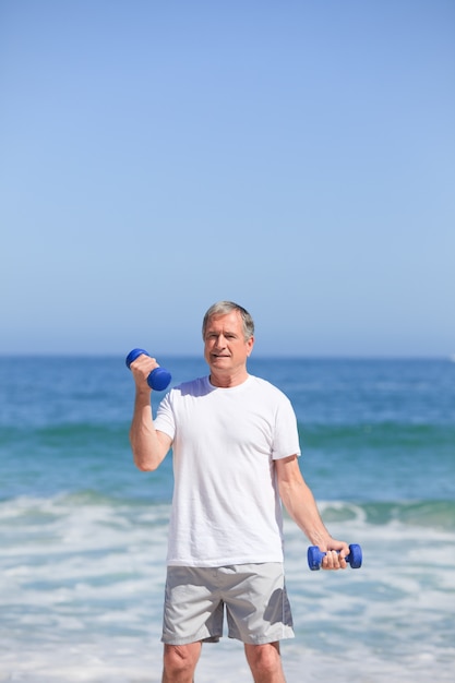 Mens die zijn oefeningen op het strand doet