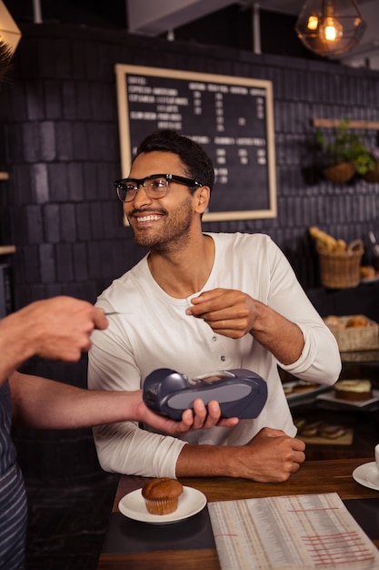 Mens die zijn rekening met creditcard betaalt