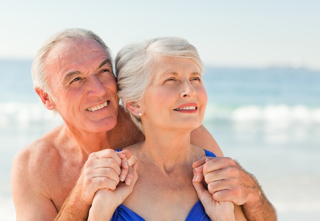 Mens die zijn vrouw koestert bij het strand