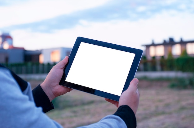 Mens die zwarte tablet in hand met het lege witte scherm houden bij de buurt