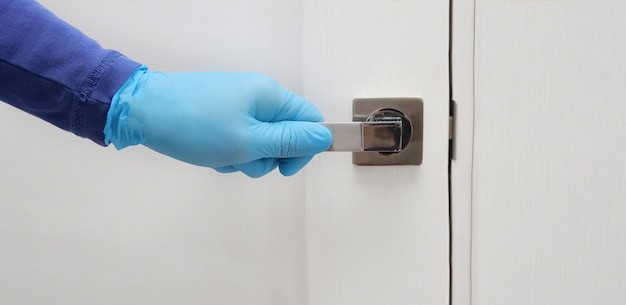 Mens hand in a blue protective gloves opens or close the door.