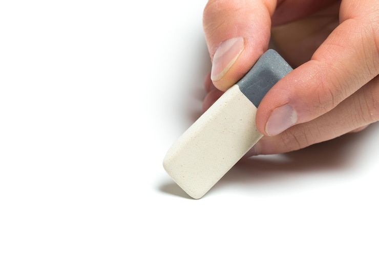 Photo mens hand holding eraser on isolated backgroung close up