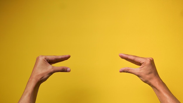 노란색 배경에서 이야기하는 두 사람의 몸짓으로 남자의 손