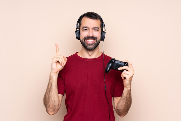 Mens het spelen met een videospelletjecontrolemechanisme over geïsoleerde muur die een groot idee benadrukken