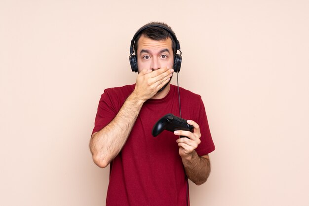 Mens het spelen met een videospelletjecontrolemechanisme over muur die mond behandelen met handen