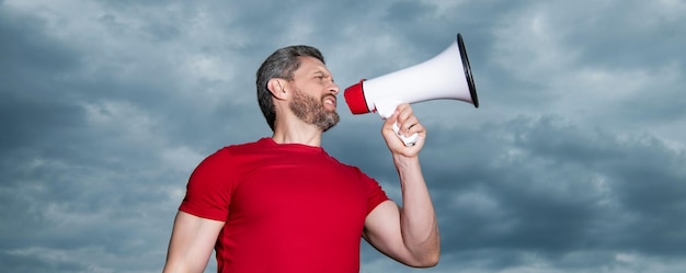 Mens in rood overhemd die in luidspreker op hemelachtergrond spreken