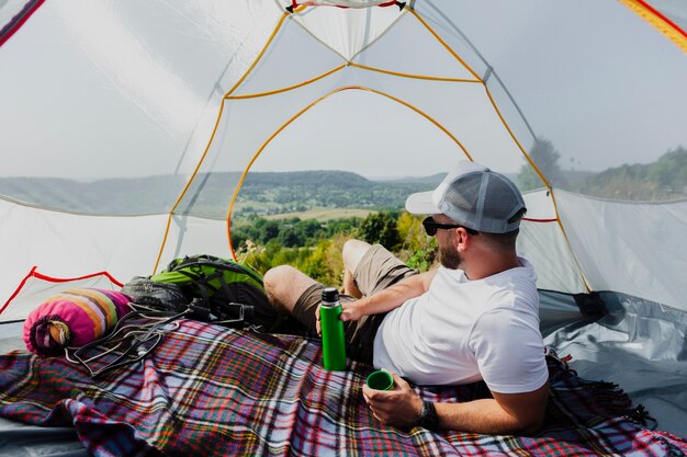 Mens in tent die en aard ontspannen bekijken