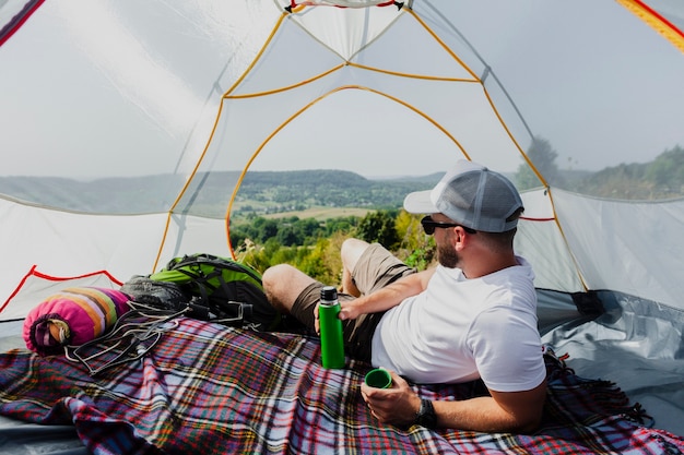 Mens in tent die en aard ontspannen bekijken