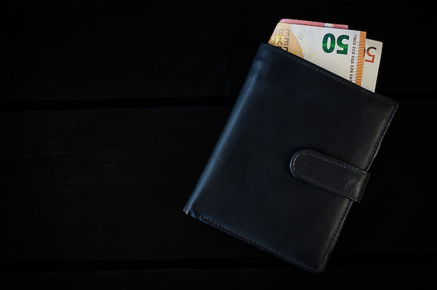 Mens leather wallet with euro, on black table