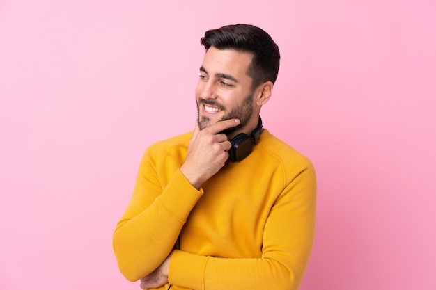 Mens met baard het luisteren muziek over geïsoleerde muur