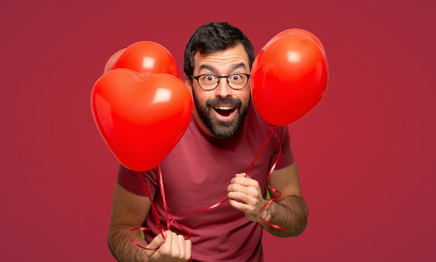 Mens met baard in valentijnskaartdag over rode achtergrond