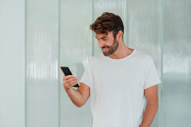 Foto mens met de witte telefoon van de t-shirtholding