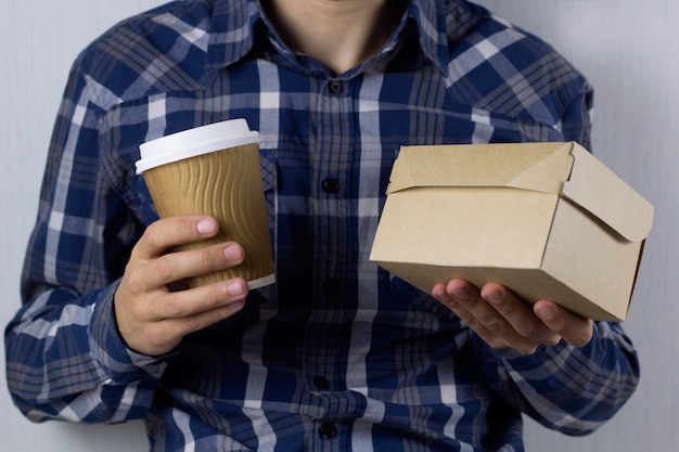 Mens met koffie en voedseldoos om te gaan