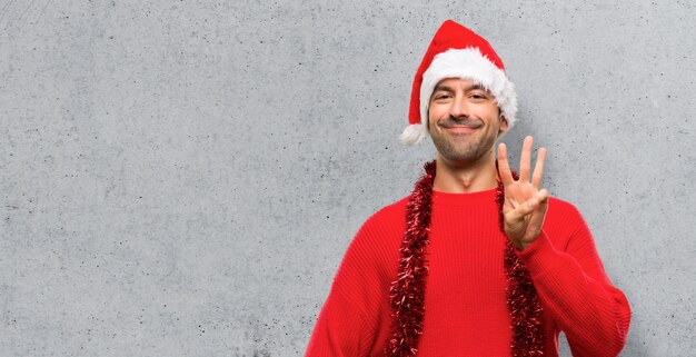 Mens met rode kleren die de Kerstmis gelukkige vakantie vieren en drie tellen