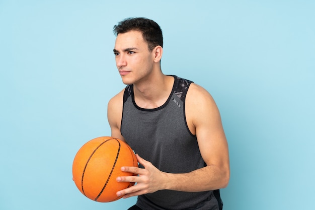 Mens op blauw muur speelbasketbal