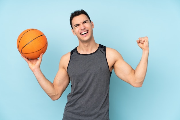 Mens op geïsoleerd blauw muur speelbasketbal