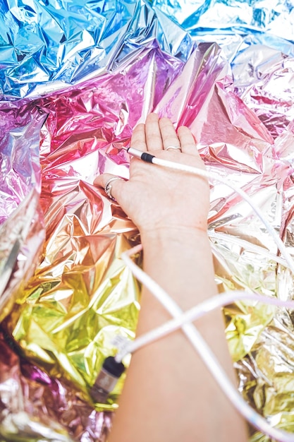 Foto menselijke hand die een draad vasthoudt met een usb-verbinding tegen een kleurrijke folie achtergrond