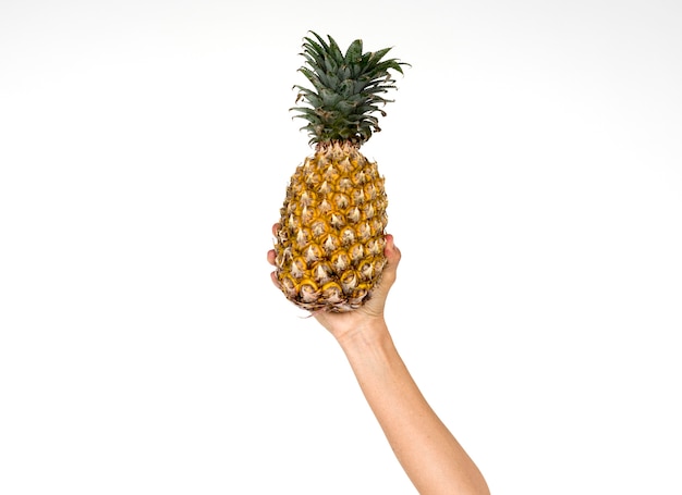 Menselijke hand met ananas fruitvoeding