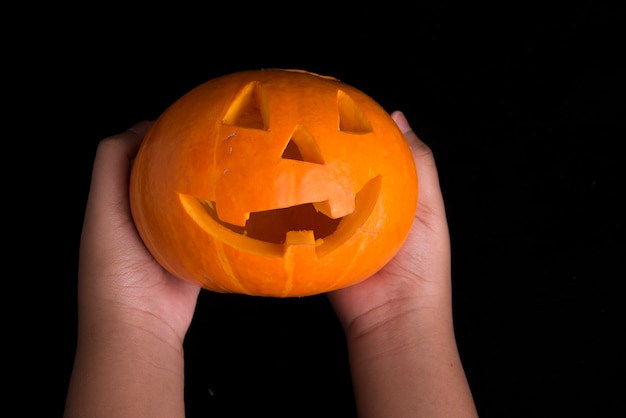 Menselijke hand met Jack-o-Lantern met een zwarte achtergrond