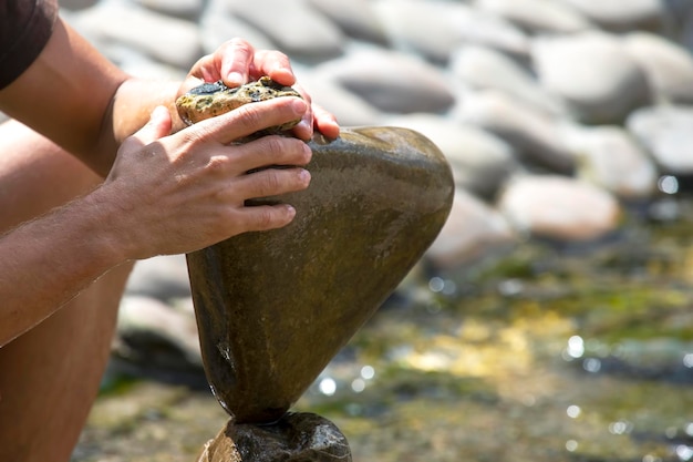 Menselijke handen bouwen een steenhoop op het water. balans en meditatie