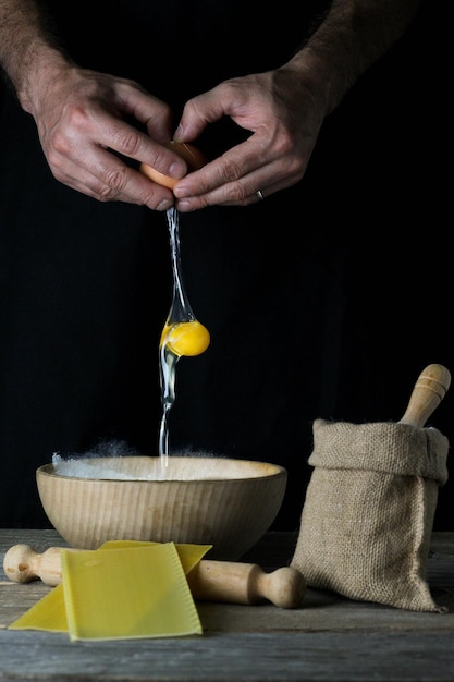 Foto menselijke handen openen ei dat over kom met bloem valt met ingrediënten ernaast