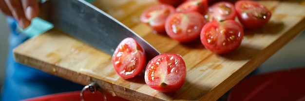 Menselijke handen snijden en hakken tomaten op snijplank groentesalade voor diner of gezonde voeding