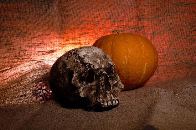 Menselijke schedel met rood licht op bruin textiel achtergrond Halloween decoraties concept