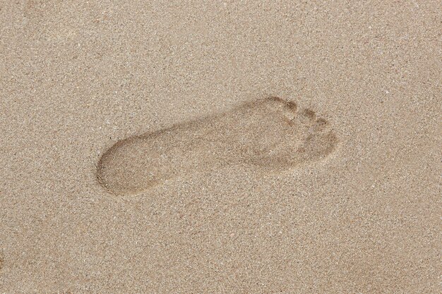 Menselijke voetafdruk in zand op het strand