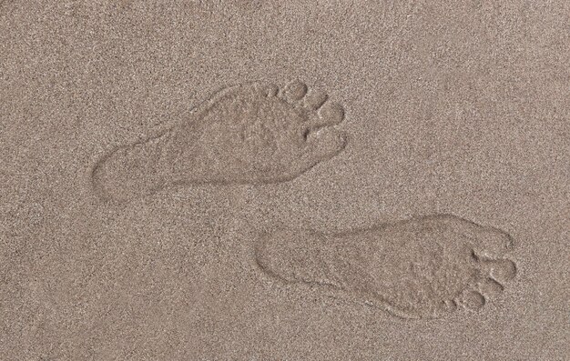 Menselijke voetafdruk in zand op het strand