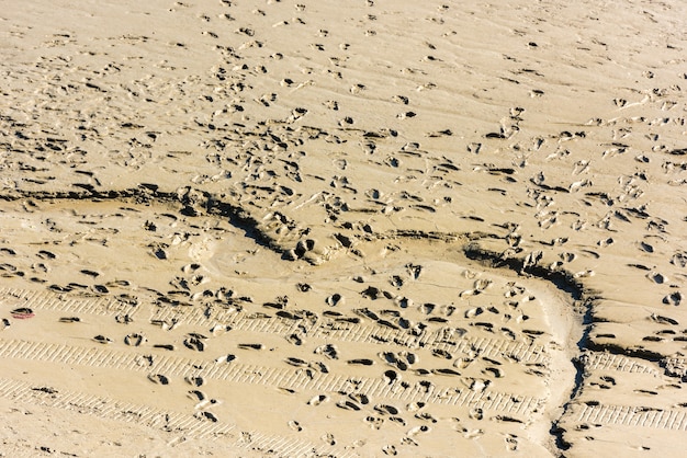 Menselijke voetafdrukken op het zand van de zeebodem tijdens eb