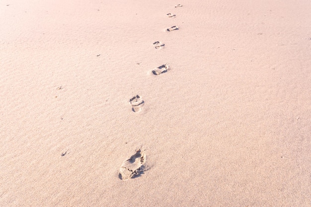 menselijke voetafdrukken op het zand van een strand