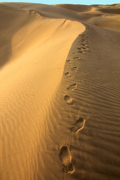 Menselijke voetstappen in het zand in de woestijn