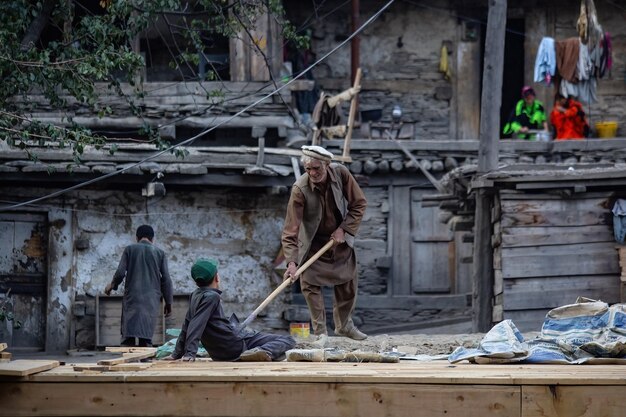 Mensen aan het werk in de buurt van het huis in het dorp Kalash in Noord-Pakistan