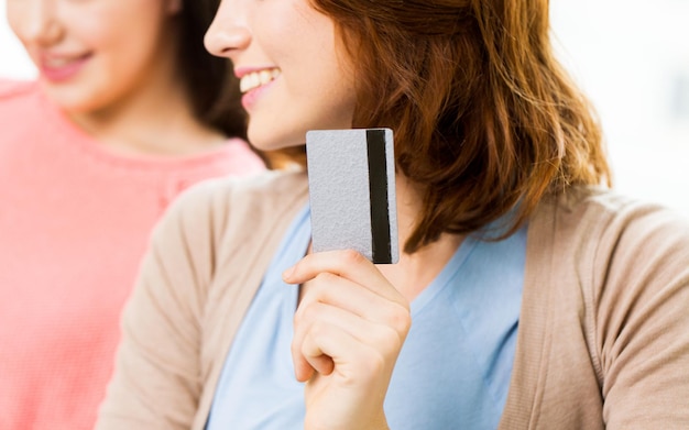 mensen, bankieren, winkelen, technologie en financiën concept - close-up van vrouwen of vrienden met creditcard