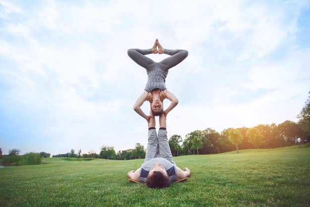 Mensen beoefenen acro yoga buitenshuis, een gezonde levensstijl