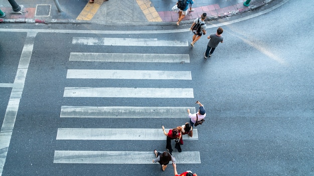 Mensen bewegen zich over het voetgangerszebrapad in de stadsweg