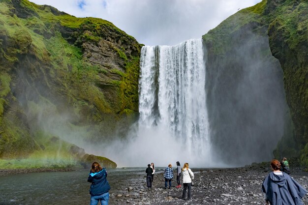 Foto mensen bij waterval tegen berg